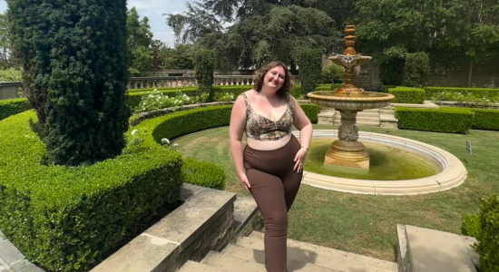 Photo of Jackie standing in a garden in front of a fountain