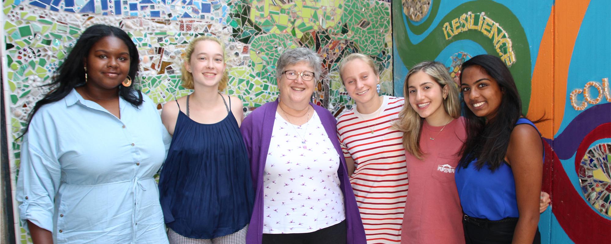 Claire Kaplan and the center's 2019-20 GVSC interns in front of the "Stronger at the Broken Places” mural. The project grew out of an annual Day of Healing and incorporates donated materials with design and labor contributions from survivors and volunteers who support them. 