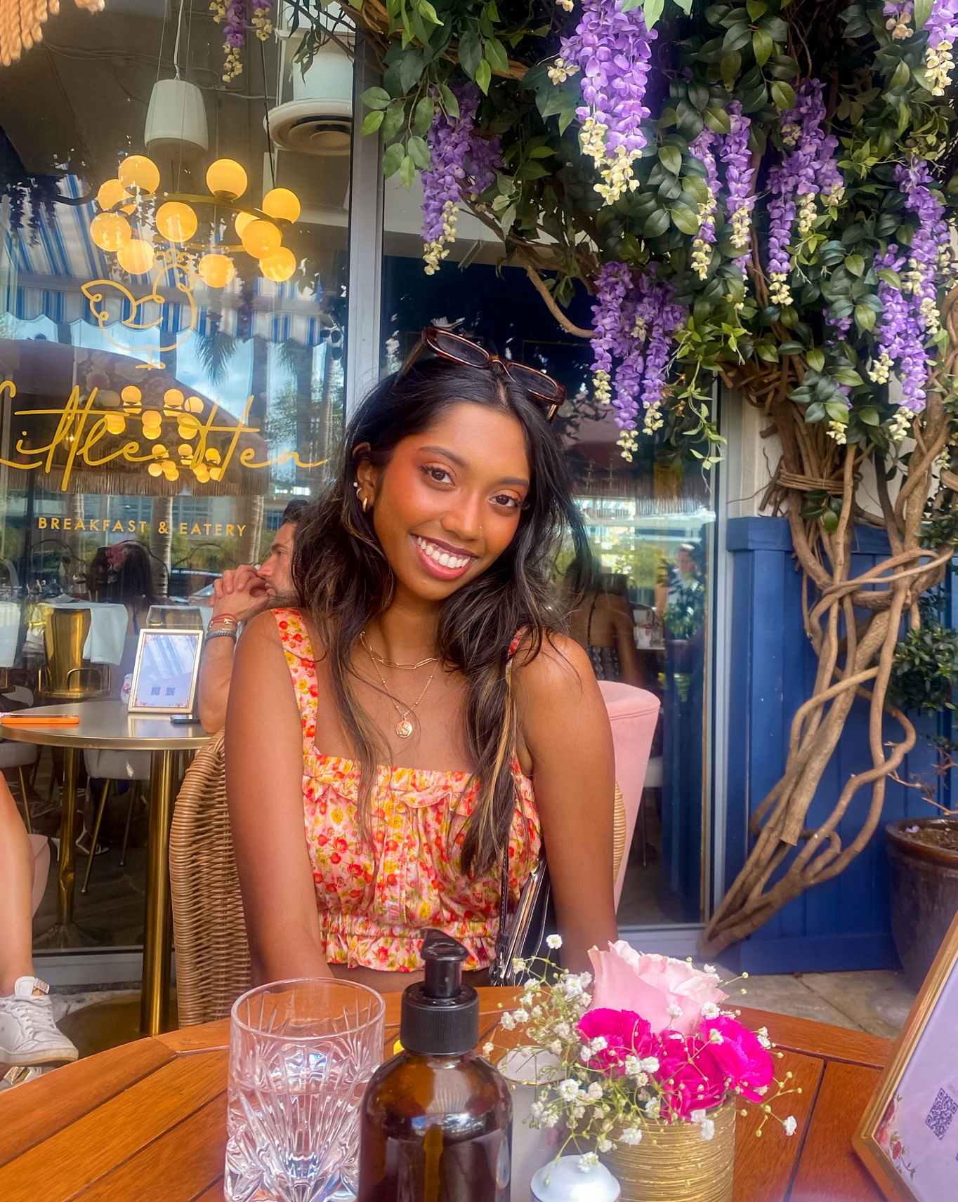 Photo of Subhi seated at a table surrounded by floral decor 