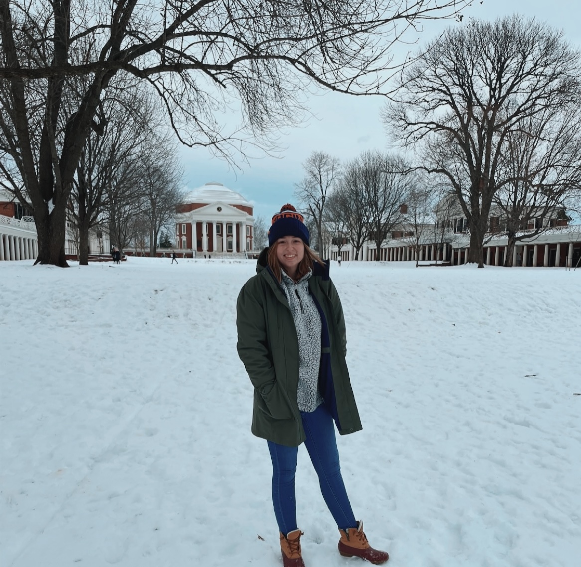 Leah standing on the lawn on a snowy day with the rotunda in the background