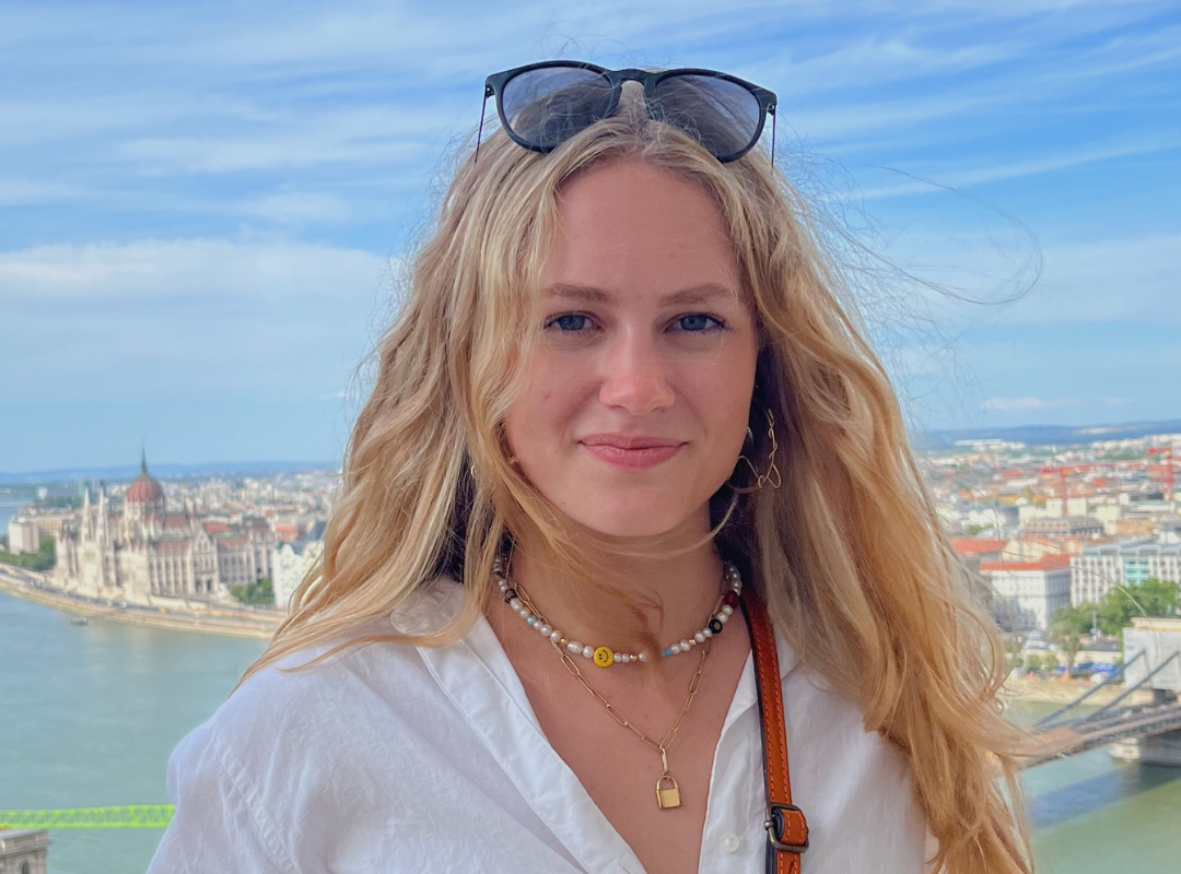 Close up photo of Eryn with skyline and water in background