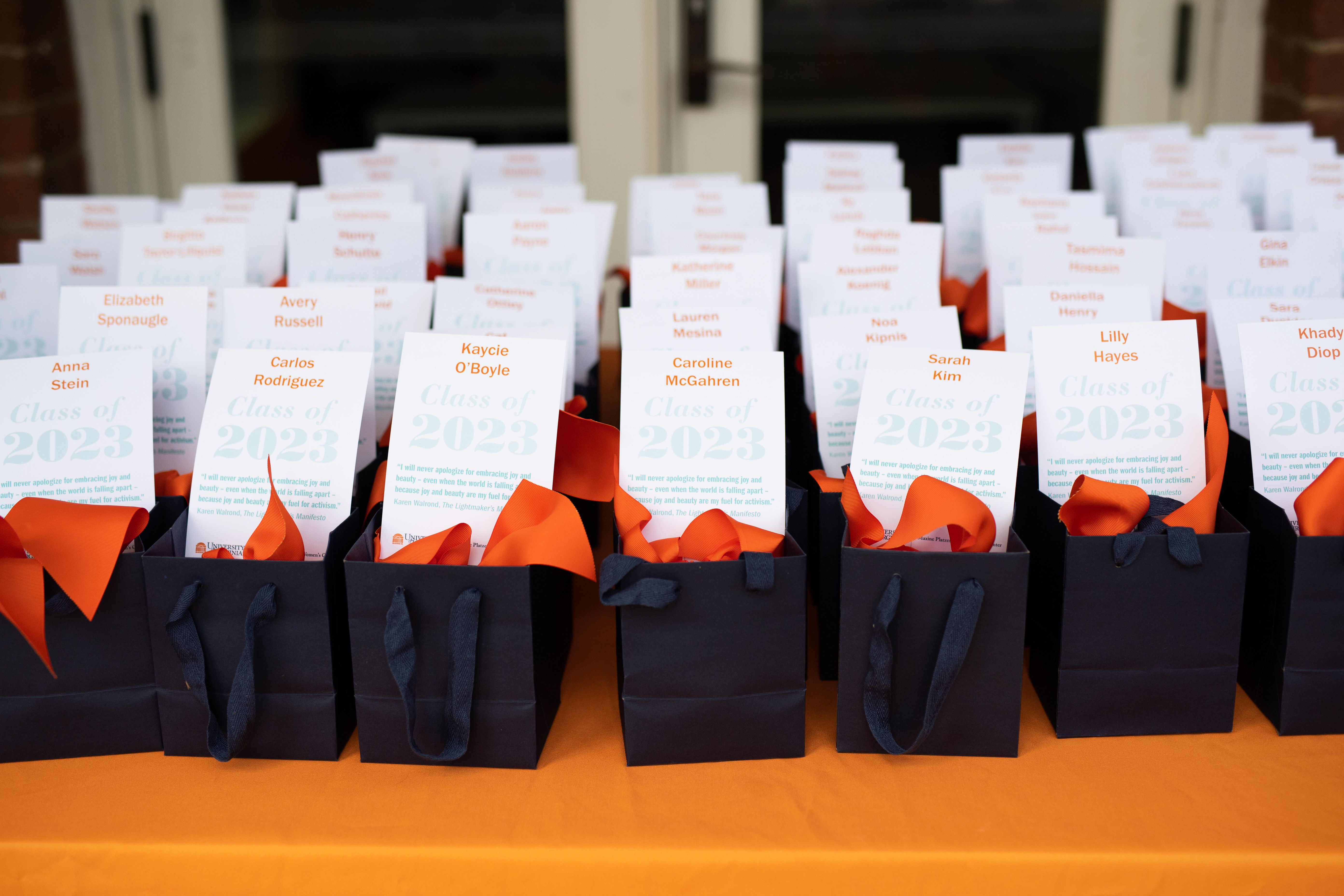 Photo of lined up gift bags with cards inside them. Cards have 2023 Women's Center graduating students' names on them.