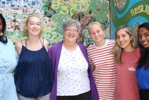 Claire Kaplan and the center's 2019-20 GVSC interns in front of the "Stronger at the Broken Places” mural. The project grew out of an annual Day of Healing and incorporates donated materials with design and labor contributions from survivors and volunteers who support them. 