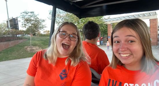 Photo of Leah and friend Brianna in a golf cart at scott stadium 